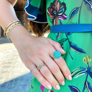 gold and turquoise rings and bracelets on model