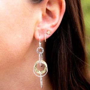 womans ear with Ippolita classico two toned jet set earring, tiny diamond hoop, and diamond star earring