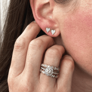 diamond heart earrings and diamond rings on model