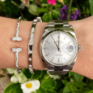 silver watch and bracelets on floral background