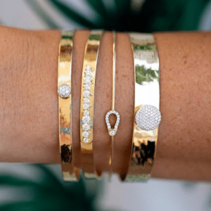 4 gold and diamond bracelets on wrist
