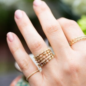 yellow gold and diamond ring stack on womands hand