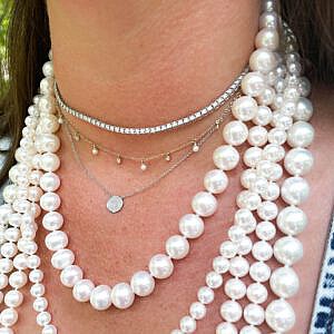 neck wearing gold and diamond circle necklace and lots of pearl necklaces
