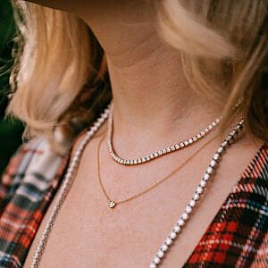 woman wearing three gold and diamond necklaces