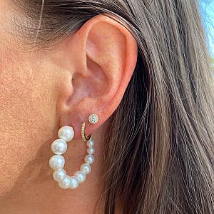 three earrings stacked on one ear on model