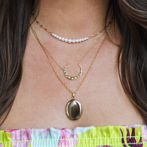 woman wearing three necklaces including gold filled locket