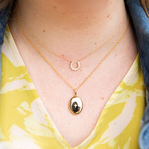woman wearing locket and horseshoe necklace