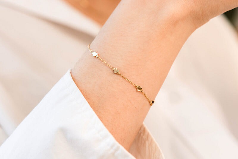 KTBRA00037 Yellow gold heart bracelet on arm